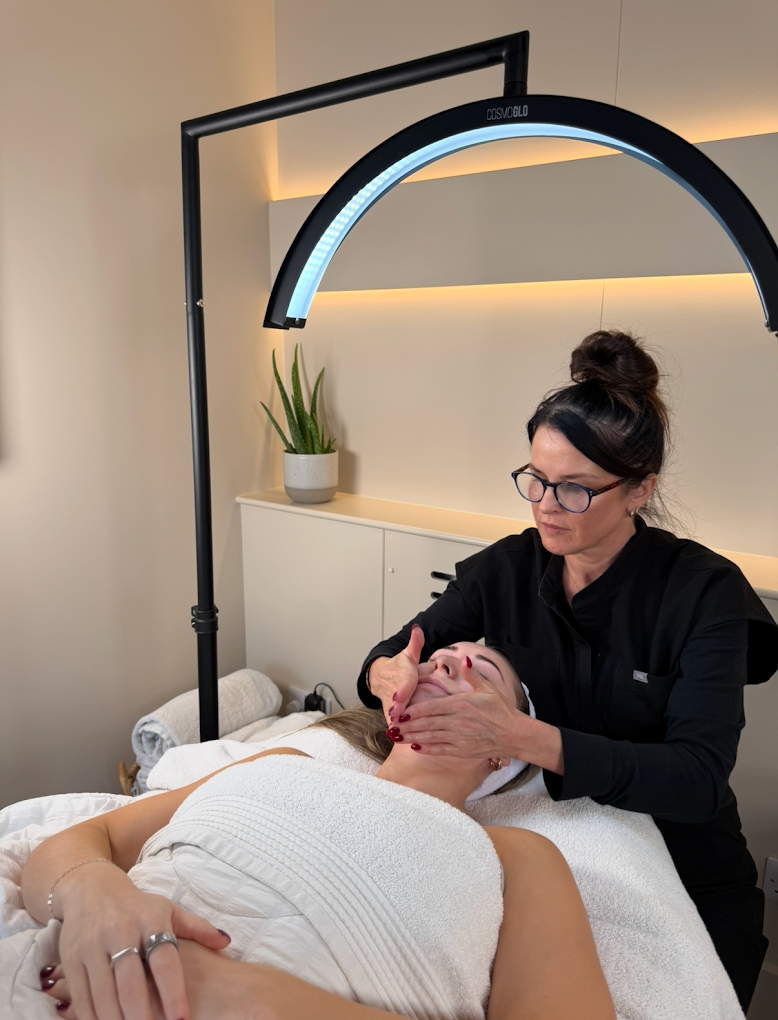 A skin therapist treating a client in a calm, modern clinic
