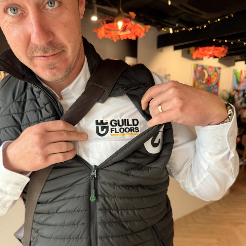 James Gillett showing the embroidered Guild Floors logo on his shirt and gilet