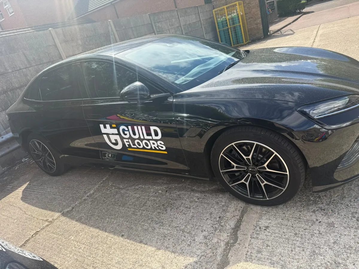 A black BYD Seal car with the Guild Floors logo on the door